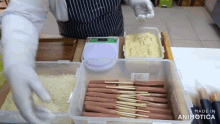 a person is preparing food in a plastic container that says made in animonica