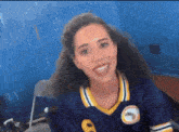 a woman wearing a number 8 jersey is smiling