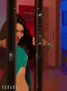 a woman in a blue crop top is dancing with carlos vargos written below her