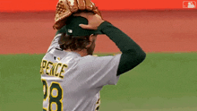 a baseball player for the a's holds his arms in the air