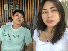 a man and a woman are posing for a picture and the man is wearing a t-shirt that says omajim