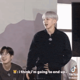 a man in a black shirt says " i think i 'm going to end up " in front of another man