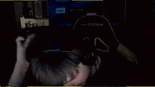 a man wearing headphones and a microphone is eating something in the dark