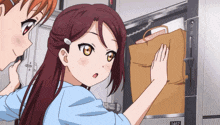 two anime girls are standing next to each other and one of them is holding a brown bag that says 2462 on it