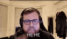 a man with glasses and headphones is laughing and saying he he .