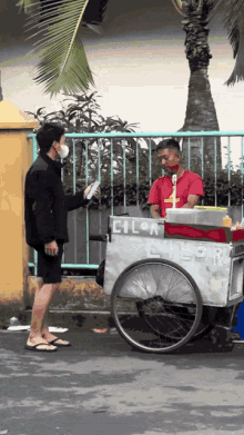 a man wearing a mask is standing next to a cart that says cila on it