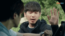 a man wearing a north face jacket is talking to another man