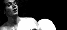 a man wearing white boxing gloves in a black and white photo