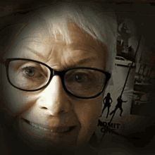 a woman wearing glasses is smiling in front of a sign that says admit one