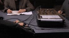a man sits at a table with a device that says ' sd ' on the front