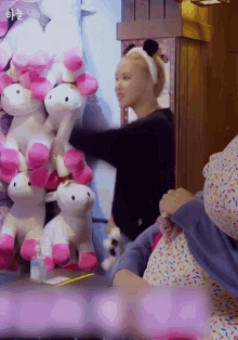 a woman is holding a stuffed unicorn in her hands