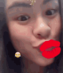 a close up of a woman making a face with red lips and a smiley face .