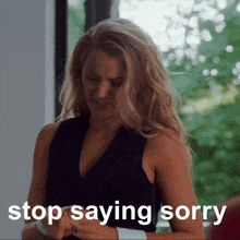 a woman says stop saying sorry while looking at her cell phone