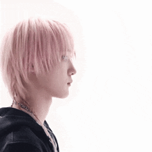 a young man with pink hair is wearing a black hoodie and a choker .