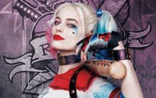 a woman in a harley quinn costume holds a baseball bat