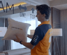 a man holding a pillow that says landoscar