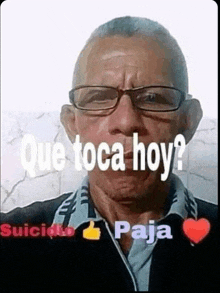 a man wearing glasses and a black shirt with the words `` que toca hoy '' on his face .