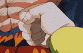 a close up of a person 's hand holding something in their fist .