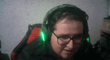 a man wearing headphones and glasses is sitting in a chair