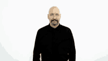 a bald man with a beard wearing a black shirt is making a gesture with his hands