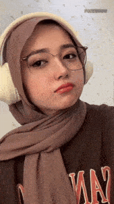 a woman wearing a hijab and headphones is wearing a shirt with the word way on it