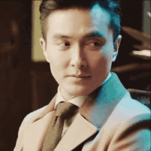 a man in a suit and tie is looking at something