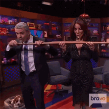 a man in a suit and tie is playing a flute next to a woman who is smoking a cigarette