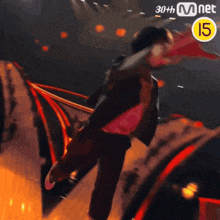a person is dancing on a stage with a 30th mnet logo