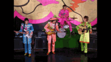 the beatles are playing their instruments on a stage