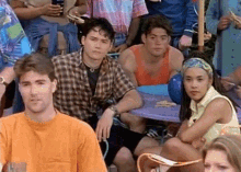 a group of young people are sitting around a table with balloons