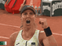 a woman with her fist in the air is wearing a itau shirt