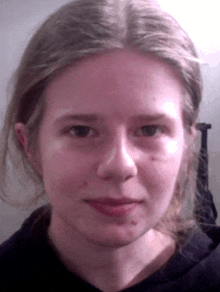 a close up of a young woman 's face with a black shirt on