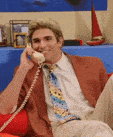 a man in a suit and tie is smiling while talking on a phone