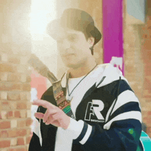 a man wearing a hat and a jacket with the letter r on it