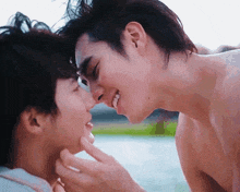 a couple of men are touching each other 's faces and smiling .