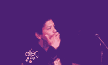 a man is standing in front of a microphone with the words ellen day 12 on the bottom