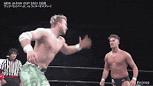 two men are wrestling in a wrestling ring and one of them is dancing .