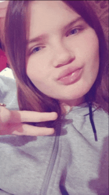 a girl giving a peace sign with her hand