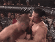 two men are fighting in a boxing ring and one of them is wearing boxing gloves