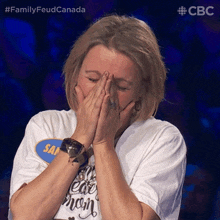 a woman covering her mouth with her hands while wearing a shirt that says i 'm a mean mom