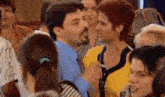 a man and a woman are standing in a crowd of people and talking to each other .