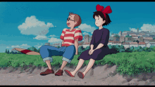 a boy and a girl sit on a grassy hill