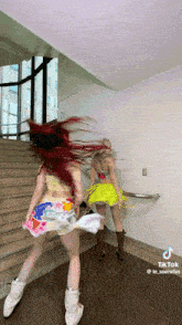 two women are dancing in a hallway with a tiktok watermark on the bottom