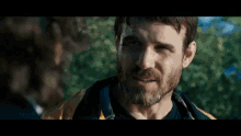 a man with a beard is smiling and talking to another man .