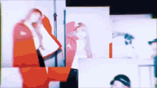 a woman in a red jacket is standing in front of a mirror and looking at herself .