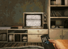 a person is holding a remote control in front of a television that says tnt on it