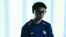 a young man wearing glasses and a blue shirt that says red bull on it