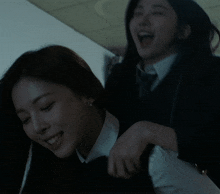 two women are playing with each other in a dark room and one is smiling