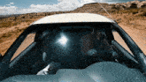 a man driving a car on a dirt road