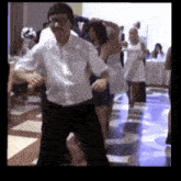 a man in a white shirt is dancing in front of a group of people